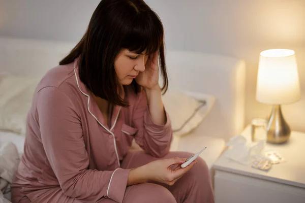 Kranke Frau Sitzt Mit Thermometer Der Hand Auf Dem Bett — Stockfoto