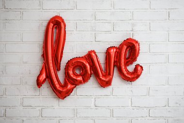 Aşk ve Sevgililer Günü kavramı - kırmızı folyo hava balonu beyaz tuğla duvar arka planında aşk mektupları