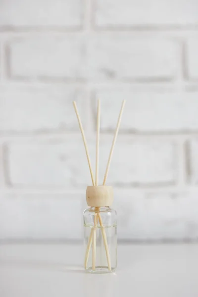 白いレンガの壁の背景に竹の棒と家庭の香りのディフューザー — ストック写真