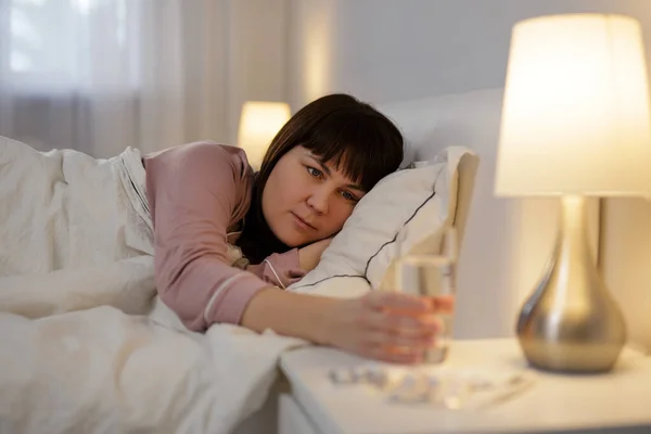 Kranke Frau Liegt Bett Und Nimmt Glas Wasser Mit Tabletten — Stockfoto