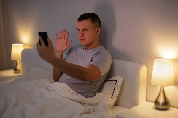 Junger Mann Winkt Handyvideo Während Ihrem Bett Liegt — Stockfoto