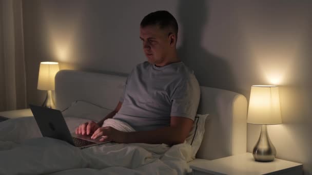 Ung Man Sitter Sin Säng Och Använder Laptop För Videosamtal — Stockvideo