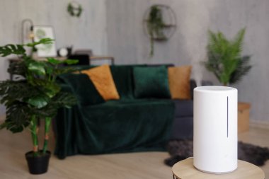 close up of modern white air humidifier in living room with scandinavian interior