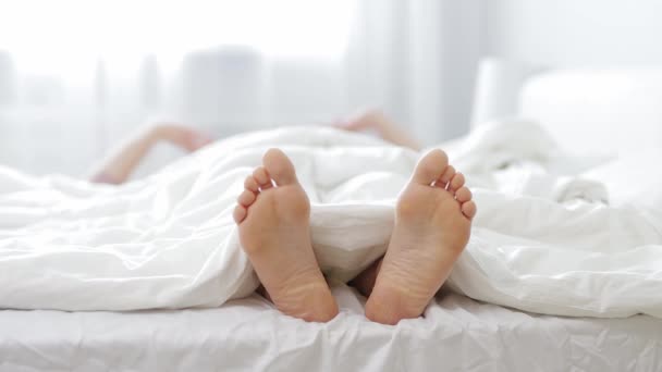 放松和快乐的概念 女人醒来后伸出手来 用白色毛毯把女性的腿围在一起 — 图库视频影像