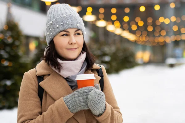 妇女在圣诞市场散步时喝着热咖啡 并装饰着节日彩灯 — 图库照片