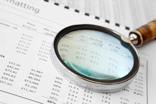 Vergrootglas over financiële document — Stockfoto