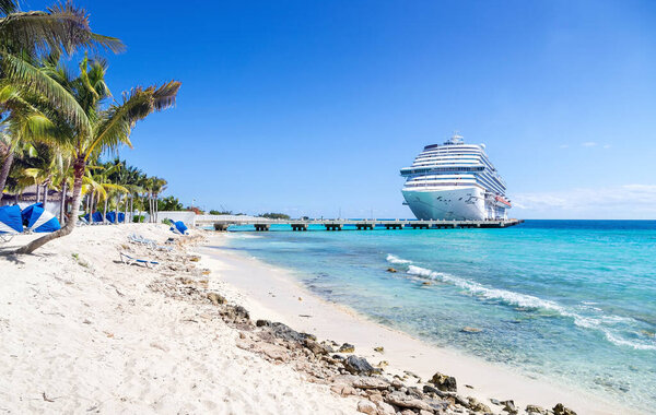 Cruise ship docked at tropical port on sunny day