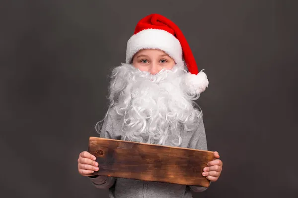 A boy 8-10 years old in a hat and with a Santa beard. mock up — Stock Photo, Image