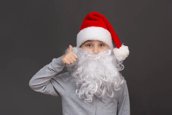 Portrait of a boy with a beard and a Santa hat shows class, thumbs up. — Stock Photo, Image