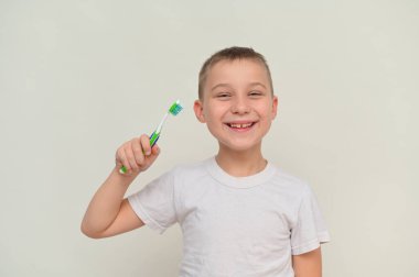 Gülümseyen bir çocuk elinde bir diş fırçası tutuyor. maket yap