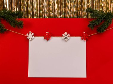 Kırmızı arka planda Noel yazıları için beyaz bir çarşaf. maket yap
