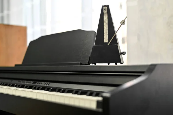 Metrónomo en un piano electrónico. enfoque selectivo. fondo musical. — Foto de Stock