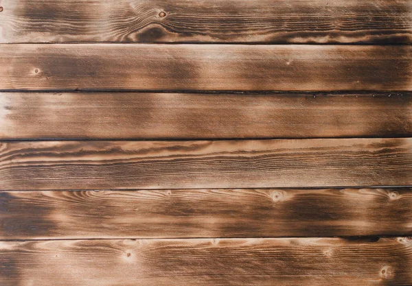 Bruine gebrande planken. de ondergrond is gemaakt van natuurlijk hout. Bovenaanzicht — Stockfoto