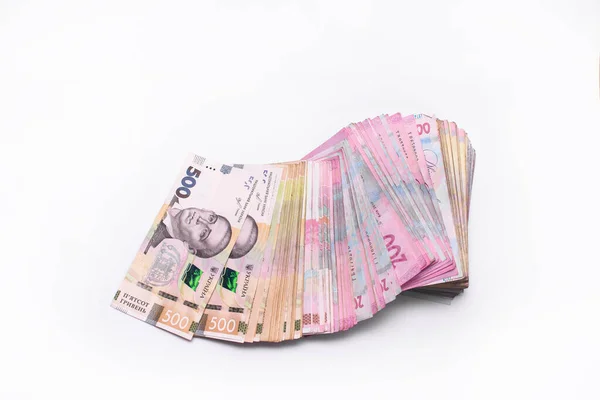 Uma pilha de notas ucranianas de hryvnia 200 e 500 num fundo branco. Um monte de dinheiro. UAH — Fotografia de Stock