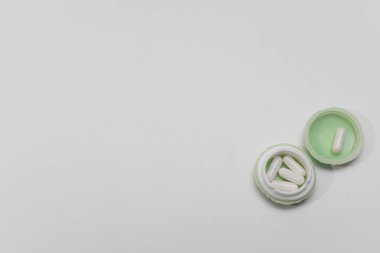 Plastik kutuda beyaz haplar. en üstteki görünüm