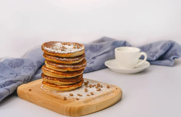 Breakfast consists of a stack of pancakes on a wooden plate. on a white background. — Stock Photo, Image