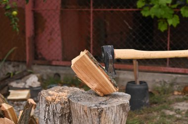 Bir balta kütüğü ikiye ayırır. Eko-yakıt. Soğuk bir kışa hazırlık konsepti.