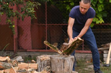 Oduncu kütüğü baltayla parçaladı. Kütüğün parçaları uçup gidiyor. Kış için yakacak odun topluyorsun..