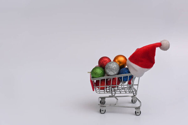 Shopping basket with Christmas balls and Santa hat..The concept of shopping for Christmas and New Year. copy space