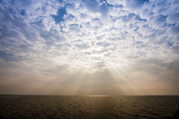 Sunbeam through the haze on the sky over the sea: can be used as background and dramatic look