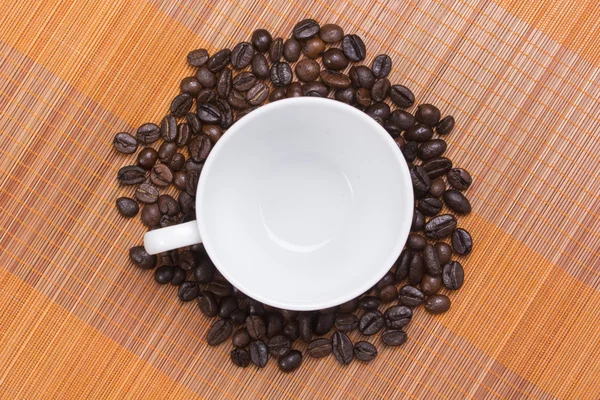 Grains de café autour tasse de café vide — Photo