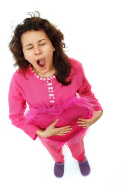 genç kız yastık üzerinde izole yawns pembe pijamaları içinde yatıyor