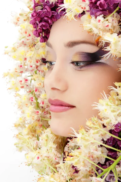 Женщина красивое лицо с цветочным сиренью и каштаном — стоковое фото