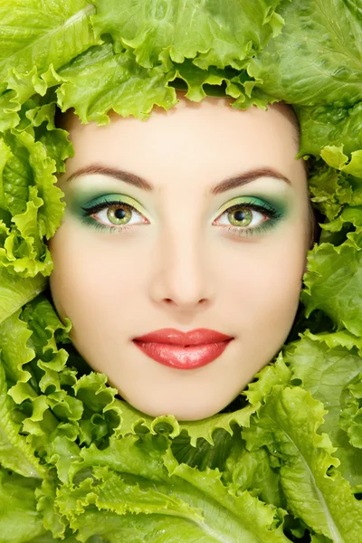 Kobieta piękna twarz z zielonej sałaty świeże liście — Zdjęcie stockowe