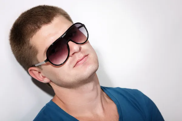 Mann junger schöner Athlet mit Sonnenbrille und T-Shirt — Stockfoto