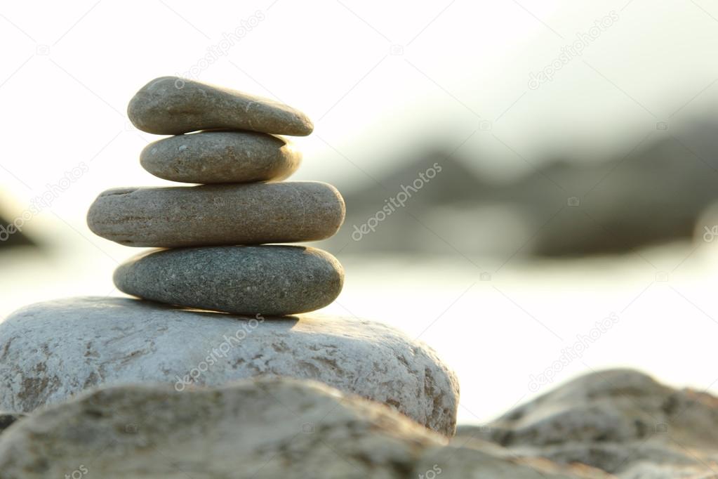 balanced stones over green nature background