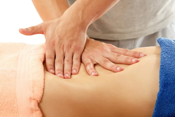 Massagista faz barriga massagem jovem mulher isolada no branco — Fotografia de Stock