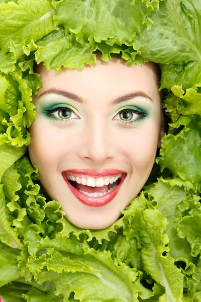 Mujer belleza cara con verde fresco lechuga hojas marco — Foto de Stock