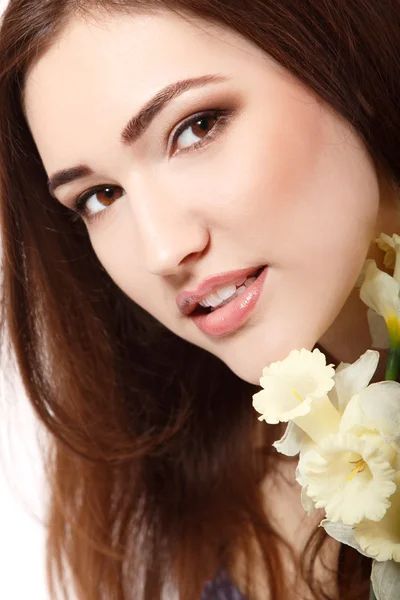 Красивая девушка-подросток, улыбающаяся нарциссом цветов — стоковое фото