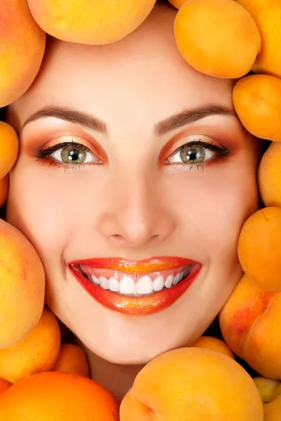 Summer portrait of young healty smiling attractive woman with ripe big fresh peaches and apricots — Stock Photo, Image