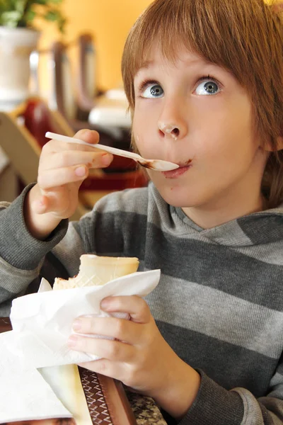 男の子の子供がかわいいカフェでアイスクリームを食べる — ストック写真