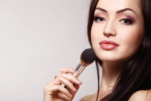 Portrait of beautiful young redheaded woman with makeup brush — Stock Photo, Image