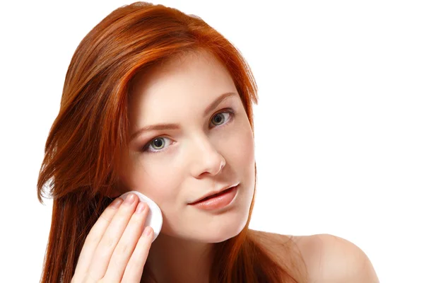 Portrait of beautiful young redheaded woman delete cosmetics with makeup sponge — Stock Photo, Image