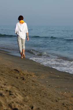 young woman walked on the beach clipart
