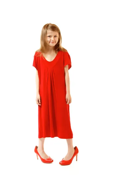 Little fashion girl in mother's red dress and shoe's on high heels — Stock Photo, Image