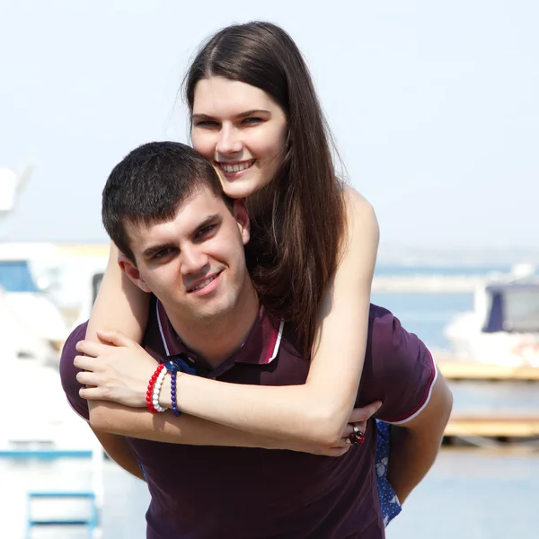 Young beautiful caucasian couple hugs and kiss - first love in seaport — Stock Photo, Image