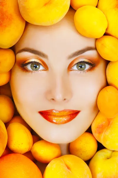 Улыбающаяся привлекательная женщина с спелыми большими свежими персиками и абрикосом — стоковое фото
