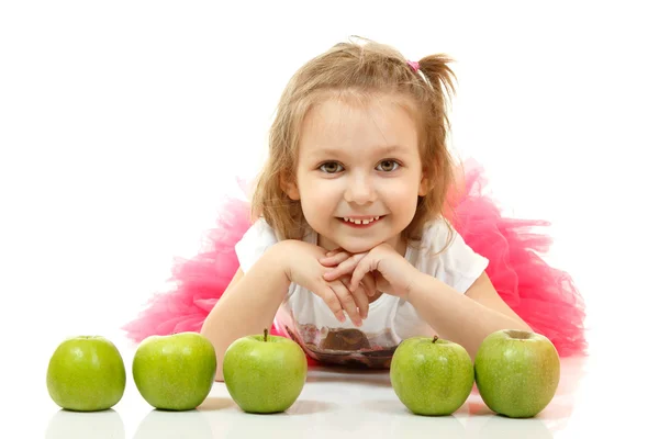 Schattig klein meisje liegen en playng met appels — Stockfoto