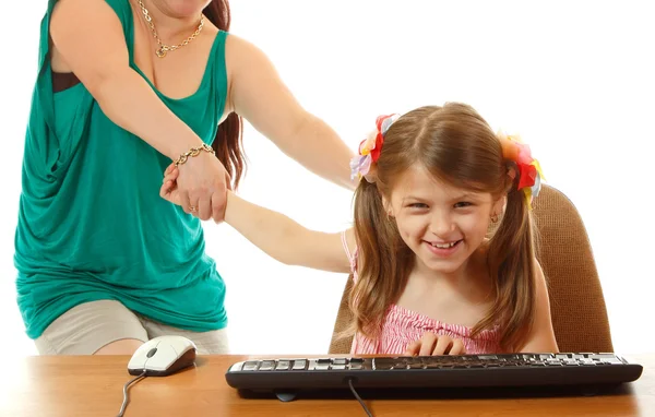 Girl with internet dependence playing with keyboard being dragged by mother from her computer — Stock Photo, Image