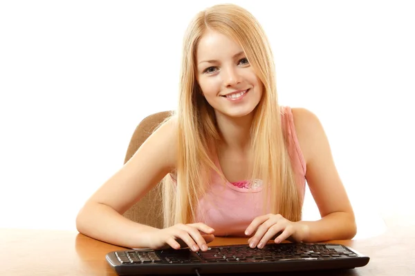 Teenie-Mädchen mit Tastatur blickt mit Interesse auf Kamera wie auf Monitor — Stockfoto