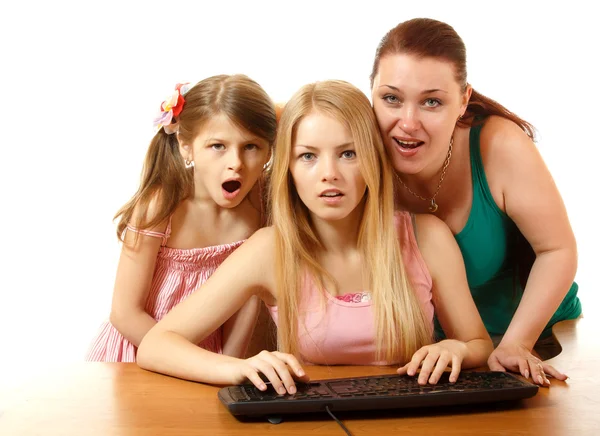 Mother with daughters looking with interest in monitor — Stock Photo, Image