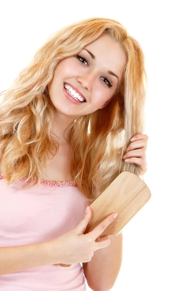 Junge fröhliche blonde Frau kämmt die Haare — Stockfoto