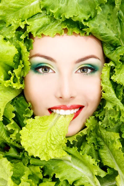 Mujer belleza cara con verde fresco lechuga hojas marco — Foto de Stock