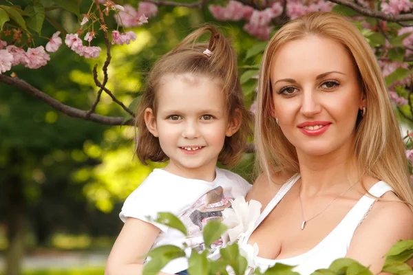 Mãe feliz com pequena filha primavera parque ao ar livre — Fotografia de Stock