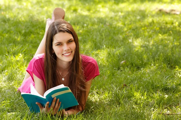 Student szczęśliwy dziewczyna czytania książki w wiosenny ogród — Zdjęcie stockowe