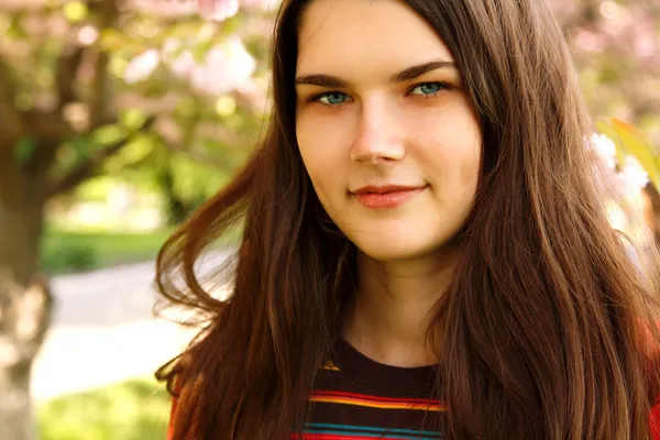 Портрет девочки-подростка, улыбающейся над садом природы — стоковое фото